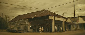 Movie still from “Blaze” (2018), directed by Ethan Hawke – Two people are walking in front of a building; Extreme Wide shot, Low angle
