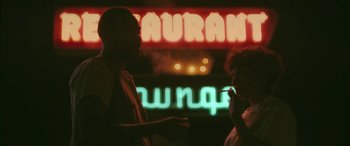 Movie still from “Blaze” (2018), directed by Ethan Hawke – A man and a woman standing next to each other; Medium shot, Over the shoulder angle