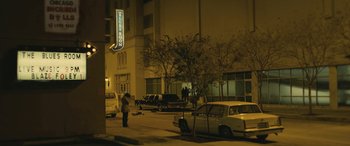 Movie still from “Blaze” (2018), directed by Ethan Hawke – A man standing on the side of the road near a car; Extreme Wide shot, Low angle
