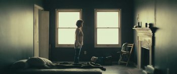 Movie still from “Blaze” (2018), directed by Ethan Hawke – A woman standing in front of two windows in a room; Wide shot, Low angle