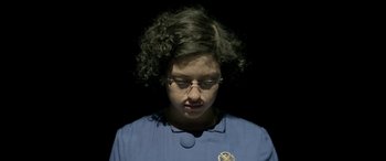 Movie still from “Blaze” (2018), directed by Ethan Hawke – A woman with glasses is looking down at her face; Close Up shot, Overhead angle