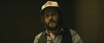 Movie still from “Blaze” (2018), directed by Ethan Hawke – A man with a beard wearing a hat and a vest; Close Up shot, Low angle