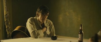 Movie still from “Blaze” (2018), directed by Ethan Hawke – A man sitting at a table with a bowl in front of him; Medium shot, Over the shoulder angle