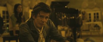 Movie still from “Blaze” (2018), directed by Ethan Hawke – A person sitting at a table; Close Up shot, Low angle