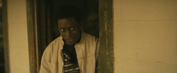 Movie still from “Blaze” (2018), directed by Ethan Hawke – A man standing next to a wall in a room; Close Up shot, Over the shoulder angle