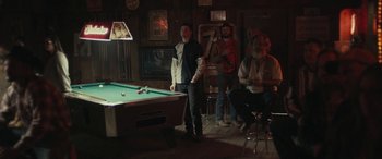 Movie still from “Blaze” (2018), directed by Ethan Hawke – A group of men playing a game of billiards; Wide shot, Over the shoulder angle