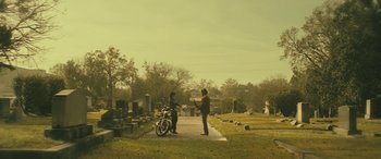 Movie still from “Blaze” (2018), directed by Ethan Hawke – Two people standing in a cemetary next to a motorcycle; Wide shot, Low angle