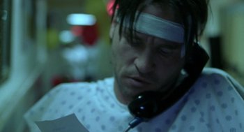 Movie still from “Blind Horizon” (2003), directed by Michael Haussman – A man with bandages on his head is talking on the phone; Close Up shot, Low angle