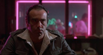 Movie still from “Blood Simple” (1984), directed by Joel Coen – A person sitting in front of a window; Close Up shot, Low angle