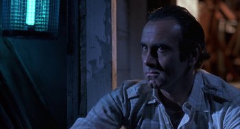 Movie still from “Blood Simple” (1984), directed by Joel Coen – A person sitting in front of a window; Close Up shot, Low angle