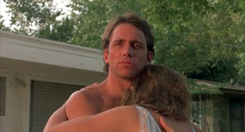 Movie still from “Blood Simple” (1984), directed by Joel Coen – A man and a woman embracing each other outside; Close Up shot, Low angle