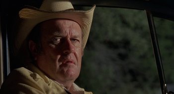 Movie still from “Blood Simple” (1984), directed by Joel Coen – A person wearing a cowboy hat; Close Up shot, Low angle