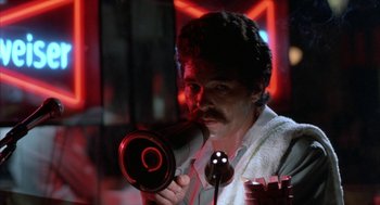 Movie still from “Blood Simple” (1984), directed by Joel Coen – A man holding a blow dryer in his mouth; Close Up shot, Low angle