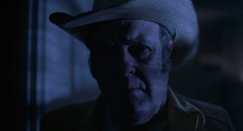 Movie still from “Blood Simple” (1984), directed by Joel Coen – A person wearing a cowboy hat; Close Up shot, Low angle