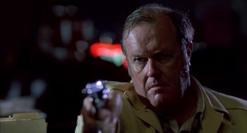 Movie still from “Blood Simple” (1984), directed by Joel Coen – A person holding a gun; Close Up shot, Low angle