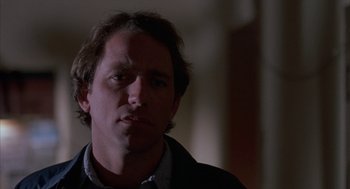 Movie still from “Blood Simple” (1984), directed by Joel Coen – A person wearing a suit and tie; Close Up shot, Low angle