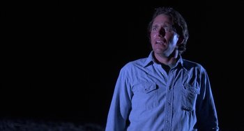 Movie still from “Blood Simple” (1984), directed by Joel Coen – A man standing in the dark with his eyes closed; Close Up shot, Low angle