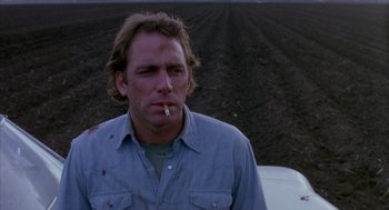 Movie still from “Blood Simple” (1984), directed by Joel Coen – A man smoking a cigarette while sitting in a vehicle; Close Up shot, Low angle