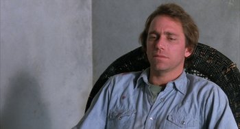 Movie still from “Blood Simple” (1984), directed by Joel Coen – A person sitting in a chair; Close Up shot, Over the shoulder angle