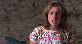 Movie still from “Blood Simple” (1984), directed by Joel Coen – A young woman making a funny face while wearing a white shirt; Close Up shot, Low angle
