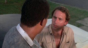 Movie still from “Blood Simple” (1984), directed by Joel Coen – A man is talking to another man outside; Close Up shot, Over the shoulder angle