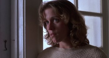 Movie still from “Blood Simple” (1984), directed by Joel Coen – A person wearing a sweater near a window; Close Up shot, Low angle