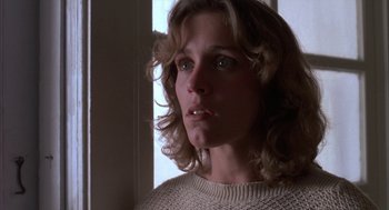 Movie still from “Blood Simple” (1984), directed by Joel Coen – A person wearing a sweater near a window; Close Up shot, Low angle