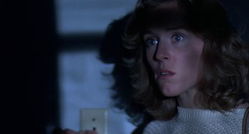 Movie still from “Blood Simple” (1984), directed by Joel Coen – A person holding a light switch; Close Up shot, Over the shoulder angle