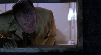 Movie still from “Blood Simple” (1984), directed by Joel Coen – A man looking at his reflection in a mirror; Close Up shot, Low angle