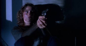 Movie still from “Blood Simple” (1984), directed by Joel Coen – A woman sitting on a bed holding a cell phone; Close Up shot, Low angle