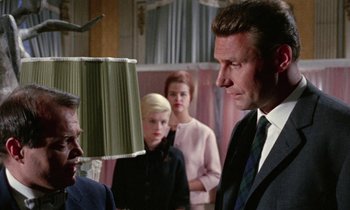 Movie still from “Blood and Black Lace” (1964), directed by Mario Bava – A group of people standing next to each other in a room; Medium shot, Low angle