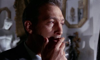 Movie still from “Blood and Black Lace” (1964), directed by Mario Bava – A person holding a cigarette in his mouth; Close Up shot, Low angle
