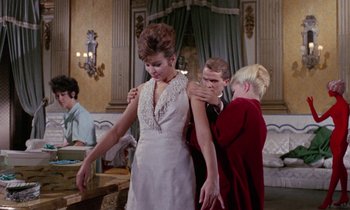 Movie still from “Blood and Black Lace” (1964), directed by Mario Bava – A man and two women are standing in a room; Medium shot, Low angle