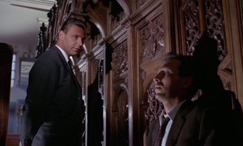 Movie still from “Blood and Black Lace” (1964), directed by Mario Bava – Two men in suits and ties standing next to each other in front of an ornate wall; Medium shot, Low angle