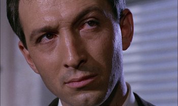 Movie still from “Blood and Black Lace” (1964), directed by Mario Bava – A man's face in a suit and tie; Close Up shot, Low angle