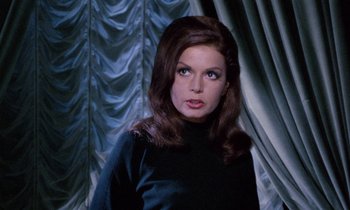 Movie still from “Blood and Black Lace” (1964), directed by Mario Bava – A woman in a black shirt is posing for a picture; Close Up shot, Over the shoulder angle
