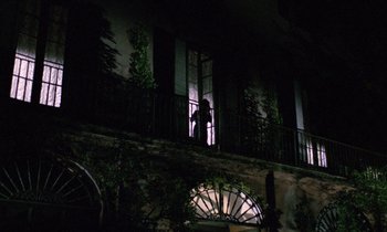 Movie still from “Blood and Black Lace” (1964), directed by Mario Bava – A person standing on a balcony at night; Extreme Wide shot, Low angle