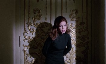 Movie still from “Blood and Black Lace” (1964), directed by Mario Bava – A woman in a black dress standing in front of a wall; Medium shot, Low angle