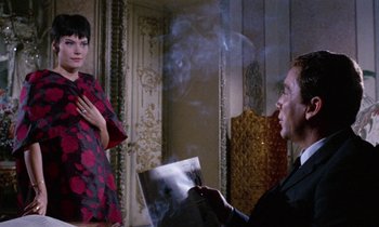 Movie still from “Blood and Black Lace” (1964), directed by Mario Bava – A man and a woman are looking at something on a paper; Medium shot, Over the shoulder angle