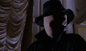 Movie still from “Blood and Black Lace” (1964), directed by Mario Bava – A man in a black hat and a black jacket; Close Up shot, Over the shoulder angle