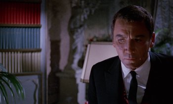 Movie still from “Blood and Black Lace” (1964), directed by Mario Bava – A person wearing a suit and tie; Close Up shot, Low angle
