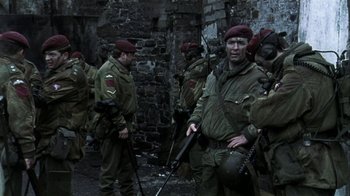 Movie still from “Bloody Sunday” (2002), directed by Paul Greengrass – A group of men dressed in military uniforms and holding guns; Wide shot, Low angle