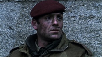 Movie still from “Bloody Sunday” (2002), directed by Paul Greengrass – A man wearing a maroon hat and a uniform; Close Up shot, Low angle