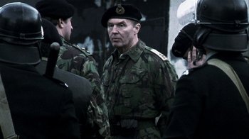 Movie still from “Bloody Sunday” (2002), directed by Paul Greengrass – A group of men in military fatigues standing next to each other; Medium shot, Over the shoulder angle
