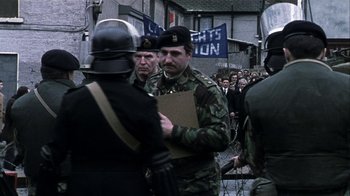 Movie still from “Bloody Sunday” (2002), directed by Paul Greengrass – A group of men in military fatigues and helmets; Medium shot, Over the shoulder angle