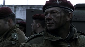 Movie still from “Bloody Sunday” (2002), directed by Paul Greengrass – A man in a military uniform and a red beret; Close Up shot, Low angle