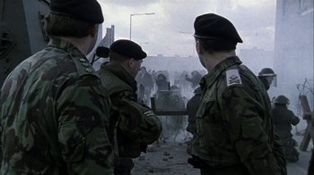 Movie still from “Bloody Sunday” (2002), directed by Paul Greengrass – A group of men standing next to each other; Wide shot, Over the shoulder angle