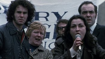 Movie still from “Bloody Sunday” (2002), directed by Paul Greengrass – A group of people standing next to each other holding a microphone; Close Up shot, Low angle