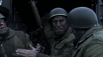 Movie still from “Bloody Sunday” (2002), directed by Paul Greengrass – A group of men in uniform holding a gun; Medium shot, Over the shoulder angle