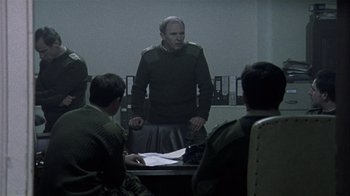 Movie still from “Bloody Sunday” (2002), directed by Paul Greengrass – A group of people sitting around a table; Medium shot, Over the shoulder angle